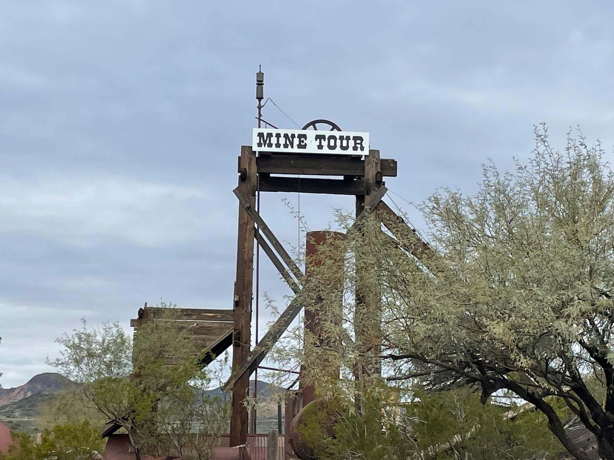 A sign for mine tours at the Goldfield ghost town, a popular attraction during a day trip.