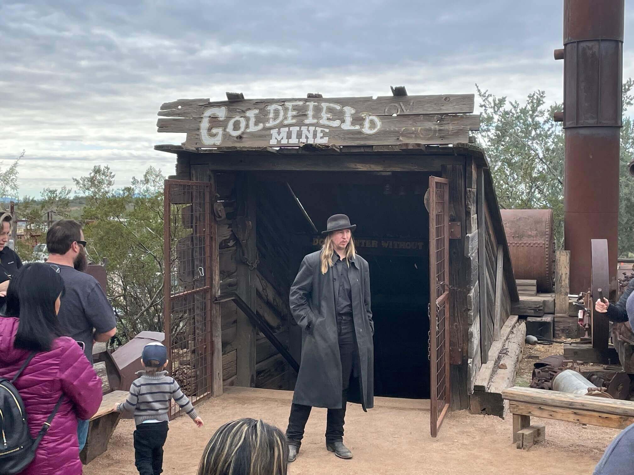 A tour guide stands before an entrance to the Goldfield mine.